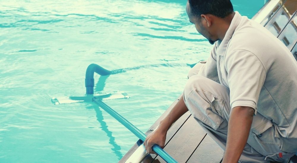 Man Cleaning Traditional Chlorine Pool